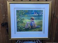 Full view of framed print showing a boy in overalls and a dog sitting on grass with children playing in background.
