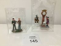 Miniature figures including two men standing together in plastic packaging with lot number card.