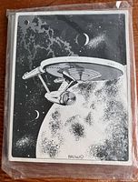 Front cover showing the Starship Enterprise near a large planet with moons and stars, signed 'Brown'.
