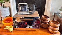 Full lot displayed with chrome and wood toaster, bread box, wooden bowls, Tupperware bowls, and measuring cups on wood surface.