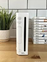Front view of white Nintendo Wii console showing power, reset, and eject buttons with disc slot.