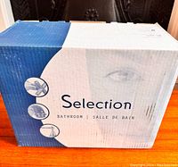 Box showing Selection Bathroom faucet branding with partial face image and product icons