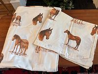 Twin pillowcase and duvet cover laid out showing horse prints and button closures