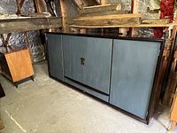 Closed view of the large blue wardrobe with a dark trim, showing three doors and the design of the front.