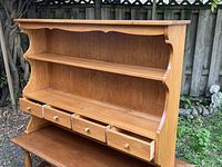 Front angled view of solid maple standalone hutch with open shelves and four drawers.