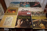 Fifteen vinyl albums arranged on table, showing covers from Deep Purple to Doors and others.