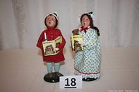 Both children figurines together, showing full bodies and details of clothing and books