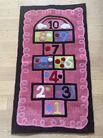 Full view of the child’s hopscotch rug showing the entire numbered pattern and border.