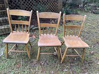 Set of three antique wooden straight chairs arranged outdoors showing overall condition and style