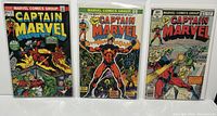 Front view of three Captain Marvel comic books including Issues #27, #32, and #62, all bagged and boarded.