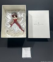 Figurine seated in original satin-lined box alongside certificate
