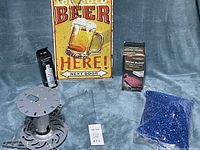 Wide view of all items: projector mount, tin sign, water bottle, water filter, and blue fish gravel bag.