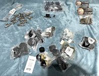 Full lot showing castor wheels, cabinet hinges, hardware sets, and knobs on a blue surface.