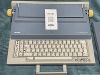 Front view of Olivetti ET Personal 55 electric typewriter showing keyboard, yellow paper adjustment knobs, and carrying handle.