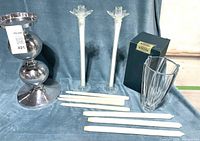 Full view of the large aluminum candle holder, two glass double wall candle holders, four white XL candles, and Crystalite vase arranged on blue fabric.