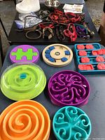 Overview of colorful dog puzzle toys and treat dispensers made of plastic