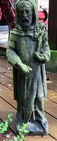 Front view of St. Francis statue with green moss patina