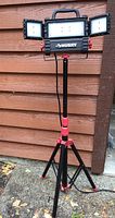 Full view of Husky LED work light on tripod stand with adjustable side panels extended.