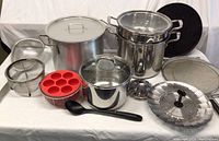 Whole set of large stainless steel pots with lids, strainers, splatter screens, silicone muffin mold, and ladle spoon.