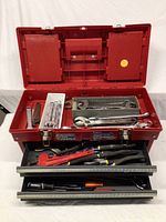 Red Stack-on toolbox open lid displaying combination and adjustable wrenches in top tray and pliers in drawer below