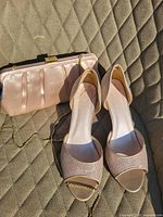 Bridal shoes and matching clutch bag displayed on quilted fabric