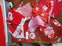 Multiple Canada Day items including small flags, red and white ribbons, and an iron-on patch on a table.