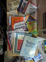 Photo showing an assortment of vintage knitting, craft, and crochet books and magazines arranged in a pile. Cover titles visible include Tatting with Anne Orr and Short-Cuts Sewing Book.