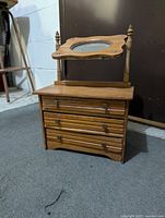 Front left angle view of the wooden dresser with mirror attached showing three drawers and wood knobs.