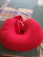 Top-down view of the red U-shaped travel neck pillow on a table, showing soft plush fabric and neck contour.
