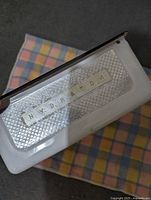 Close-up of white enamel drawer showing metal label with 'HYDRATOR' text.