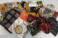 Top view showing variety of folded scarves with different colors, patterns including plaid, florals, and abstract prints.
