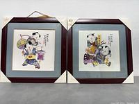 Two framed hand painted Chinese ceramic tiles with corner protectors, each 13x13 inches, showing children with lanterns and Chinese calligraphy.