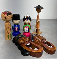 Group photo showing four traditional Korean wooden dolls and two carved Talchum masks on table