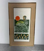 Full view of the framed limited edition print showing the bird and orange sun with reeds below, set in beige mat and gold frame.