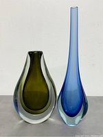 Two Sommerso glass vases together on neutral background, showing relative size and color contrast (olive green and blue)