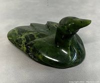 Front side view of polished carved green jade duck showing rich color, surface, and artist signature.