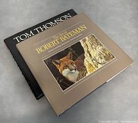 Two art books stacked with Tom Thomson book underneath and The Art of Robert Bateman book on top showing cover details.
