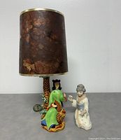 Full view of the vintage porcelain table lamp with Asian lady figure base and brown textured lampshade