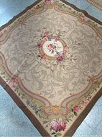 Full view of square tapestry rug laid flat on floor.