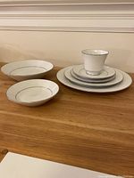One place setting: dinner plate, salad plate, bread & butter plate, soup bowl, cup and saucer on table