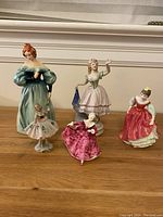 Image showing all five porcelain figurines in a group with various dresses and colors.