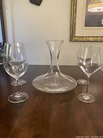 Wide shot showing the decanter centrally placed with two Riedel wine glasses on each side.