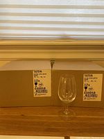 Two cardboard boxes each labeled for 12 Royal Leerdam wine tasting glasses with one clear wine glass set in front of the boxes.