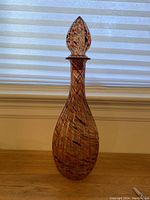 Full view of the tall art glass genie bottle showing its elongated teardrop shape with a matching stopper on top.