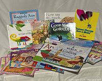Photo displaying 16 visible paperback children’s picture books, colorful covers showing titles and illustrations.