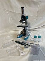 The microscope and accompanying accessories placed on a white background, showing all items included in the lot.
