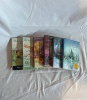 Photo of seven paperback books from The Chronicles of Narnia series arranged in a row, showing the cover art and titles.