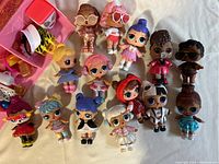 14 LOL dolls with various hairstyles and colorful outfits arranged next to 3 LOL pets.