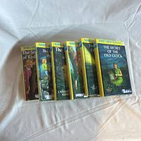 Six Nancy Drew hardcover books with yellow spine bands titled volumes 1-6, showing front covers with illustrated mystery scenes.