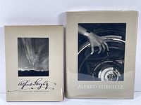 Front covers of two Alfred Stieglitz photography books showing dust jackets with photographic images.